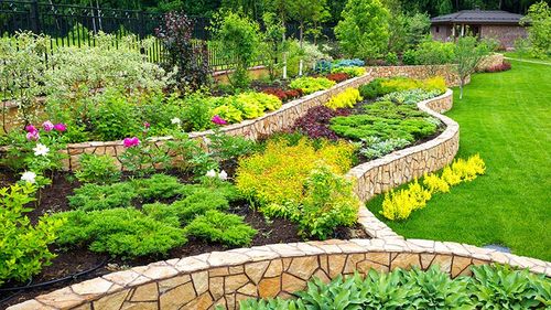 multi-tier retaining wall with lush garden of shrubs and flowers