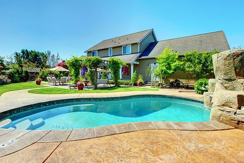 Kidney-shaped inground pool with natural stone coping