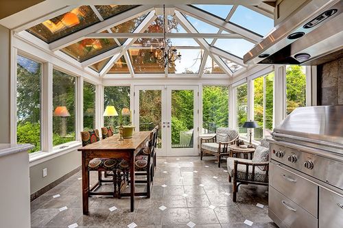 white trimmed sun room with large windows and glass roof