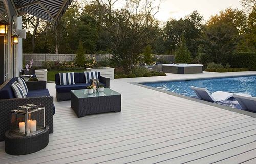 deck surrounding a pool with patio furniture