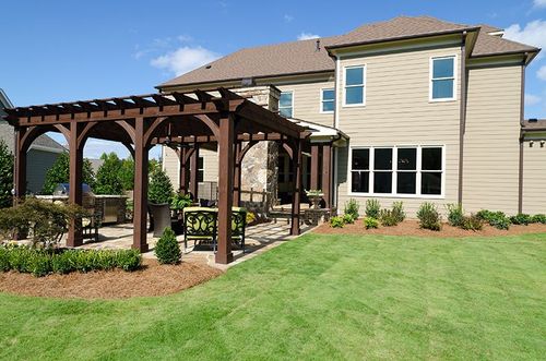 dark wood pergola on concrete patio