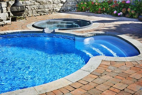 unique circular-shaped pool with attached hot tub