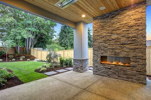 outdoor floor to ceiling fireplace underneath patio roof structure