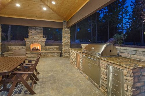 outdoor kitchen with built-in grill, sink, and refrigerator