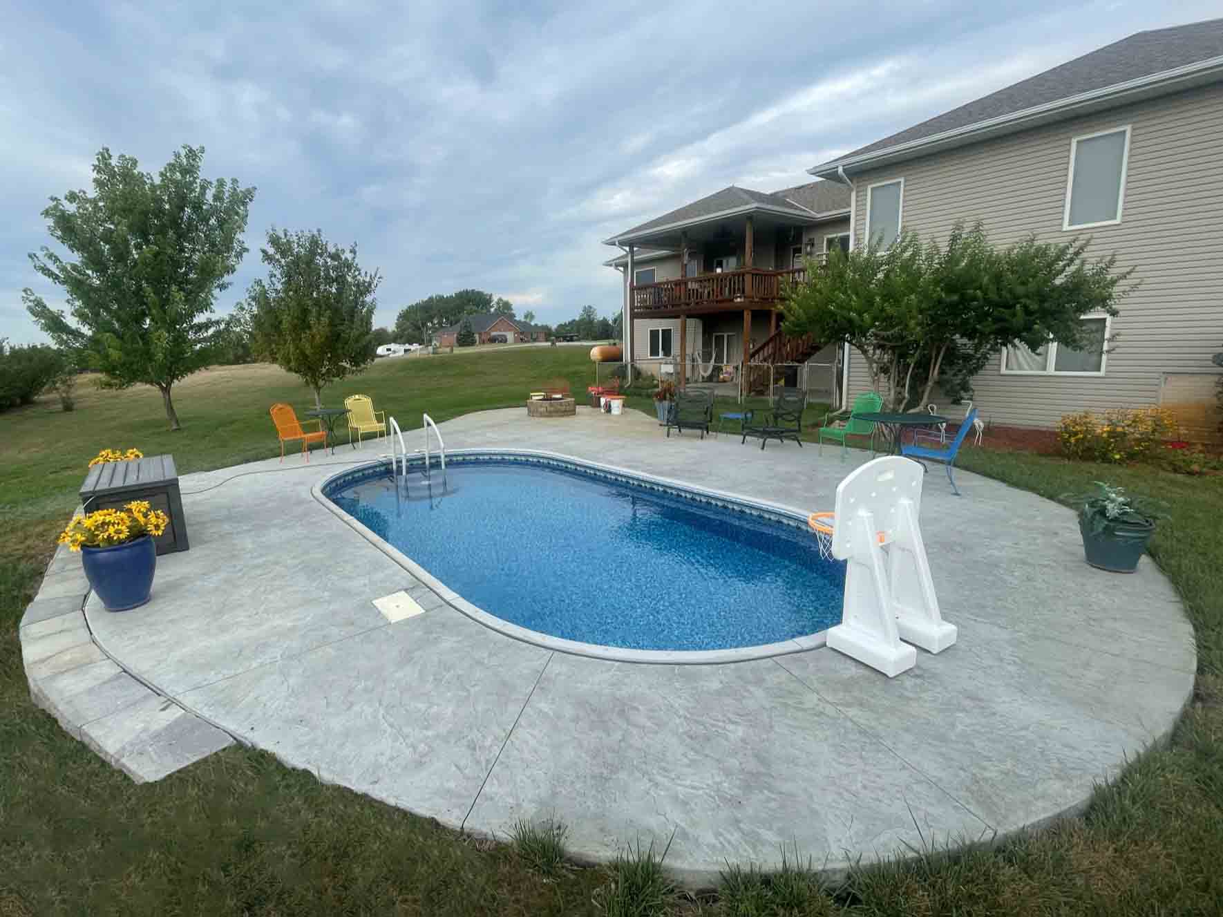in-ground pool with surrounding concrete patio